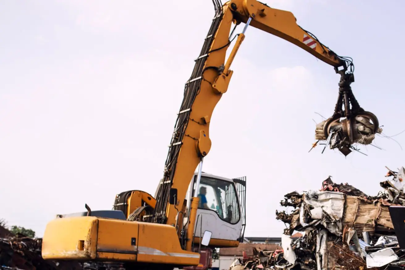 Heavy material-handling excavator with a grapple at work